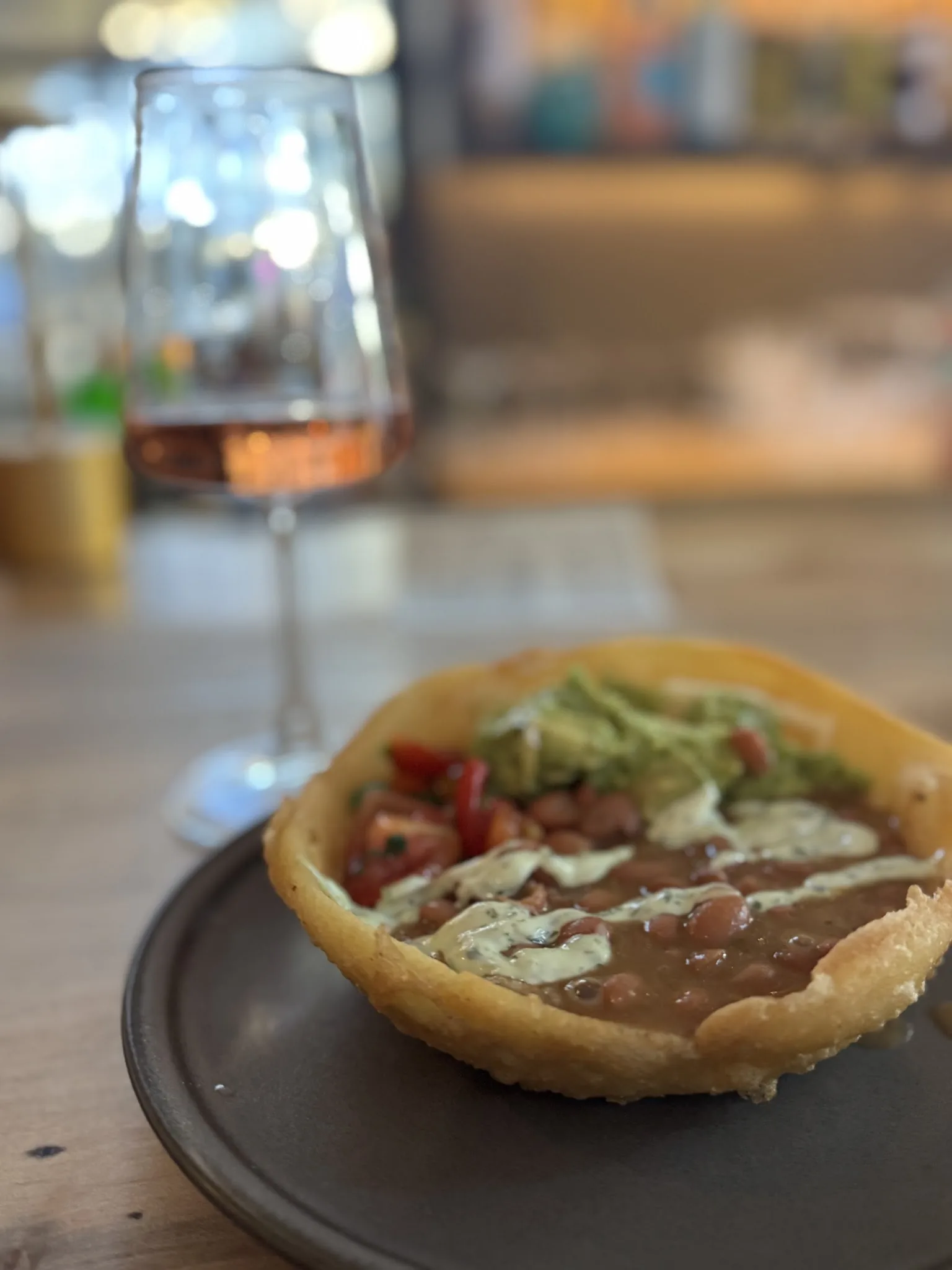 A deep fried arepa bowl with beans, guacamole and pico