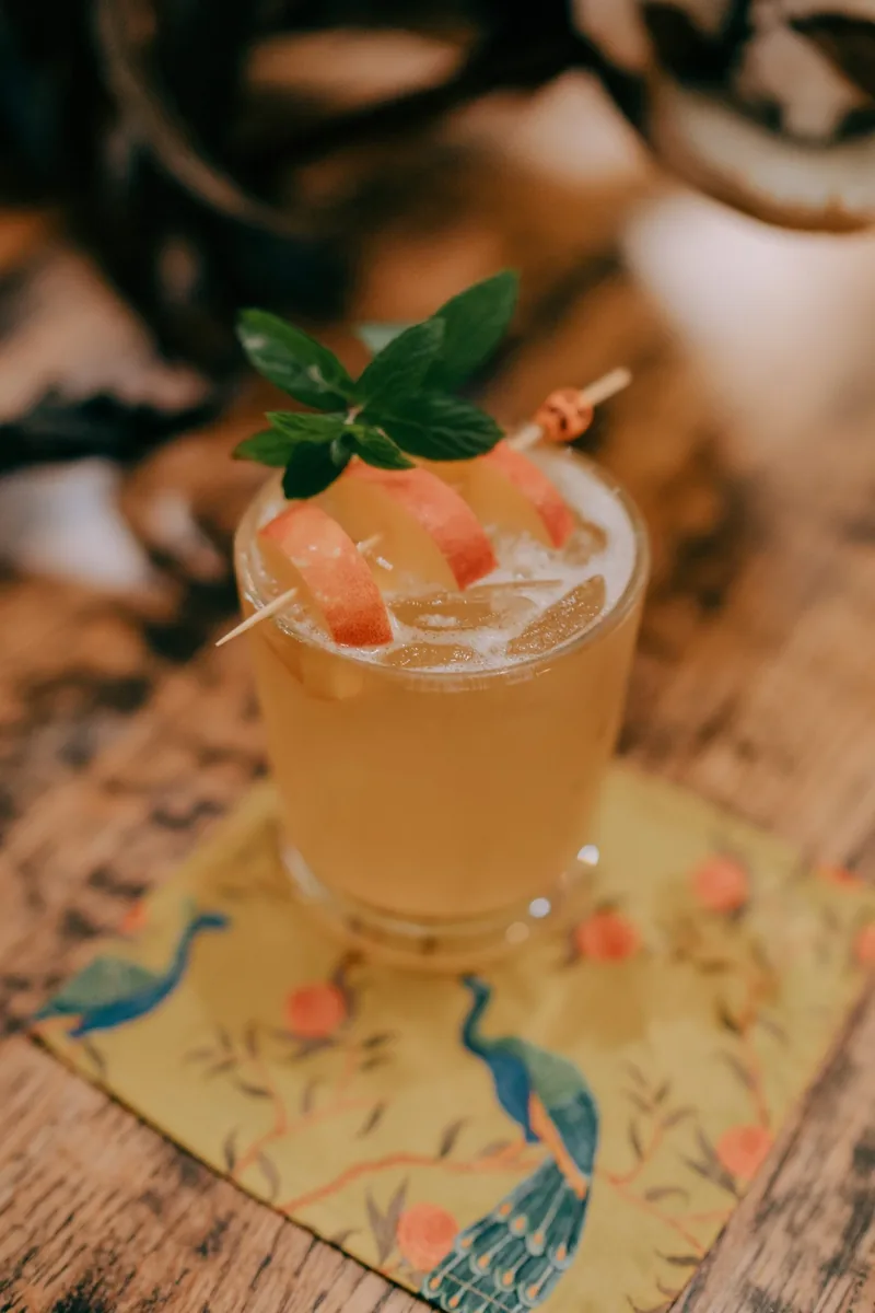 A garnished cocktail on a printed heron mat